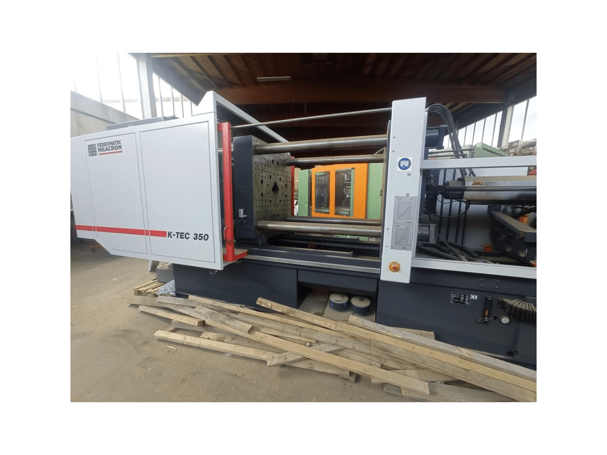 K-TEC 350 de Ferromatik Milacron, vista lateralmente, mostrando su compleja maquinaria y controles operativos.