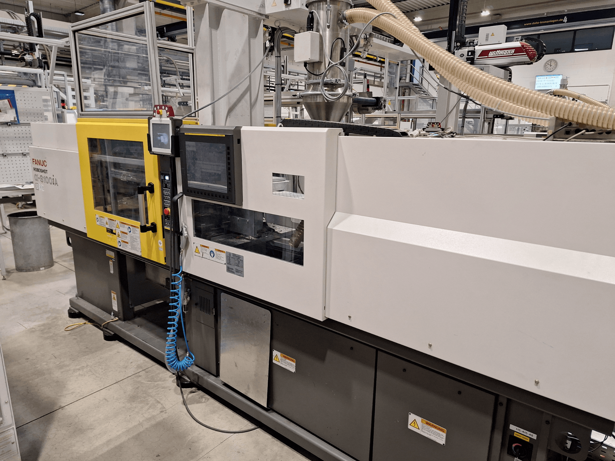Máquina de moldeo por inyección FANUC Roboshot α-S300iA, vista frontal, con panel de control y componentes industriales visibles.